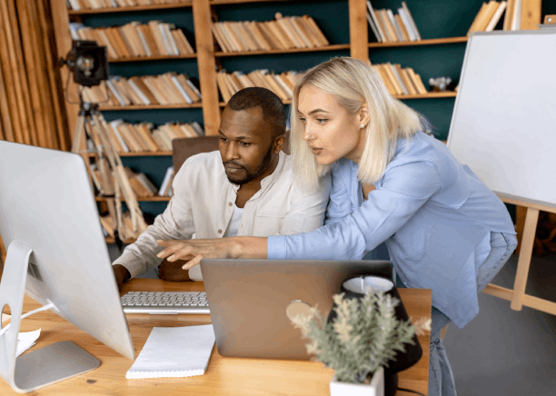 Two linguists review a user manual draft with a translator, showing Translation Services in Richmond for technical documents.