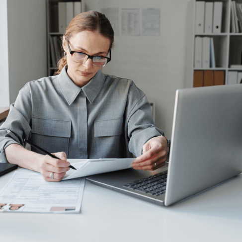 A translator review USCIS forms on a laptop, confirming names and dates with Translation Services in Richmond.